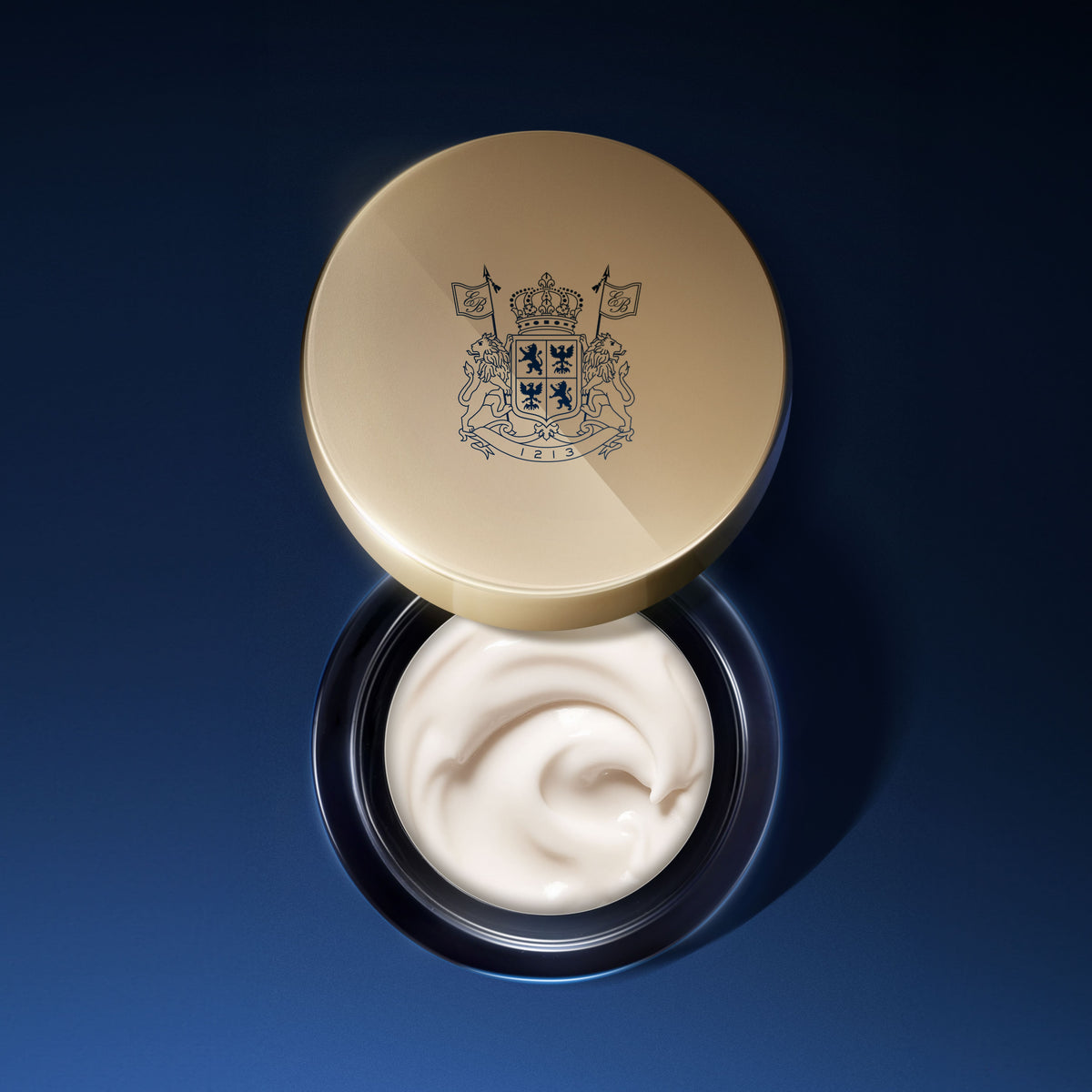 Open jar of EviDenS de Beauté rich face cream against a deep blue background